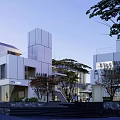 Modern Commercial Street With White Buildings Trees Steps And Evening Pedestrians