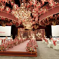 Elegant Event Stage With Floral Decorations Chandeliers Screens And Table Settings