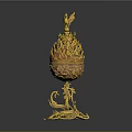 Golden egg shaped decorative ornament set with bird on top and intricate base design