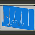 Sterile Medical Instruments Organized on Metal Tray with Blue Cloth and Surgical Tools