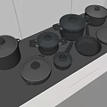 Kitchen Cookware on Black Countertop with White Cabinets Including Covered Pots and Silver Pans