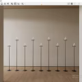 Nine Black Candle Lamps Neatly Arranged In Room With Light Colored Wall And Wooden Floor