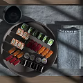 Assorted Sushi Rolls On Gray Ceramic Plate With Wooden Table Gray Cup And Linen Cloth