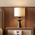 Black Table Lamp With Beige Fabric Shade On Wooden Bedside Table Against Wooden Wall Panel