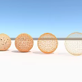 Intricate Hollow Spherical Sculpture Carvings In Four Colors Against Light Blue Sky And Light Ground