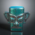 Teal Colored Carved Head Sculpture With Symmetrical Ears And Geometric Facial Design