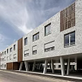 Modern Multi Storey Residential Building With White Exterior Wooden Elements And Street Lamps