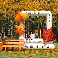 Inflatable Arch With Autumn Maple Leaf Decorations In Woodland Park Setting And Fall Foliage Accents