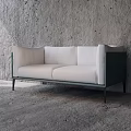 Modern White Two Seater Sofa With Metal Frame And Black Legs Against Grey Concrete Wall