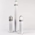 Three Silver Outdoor Lights With Tall Center Shorter Sides Cylindrical Poles Round Shades Metallic Finish