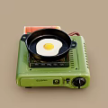 Portable Green Gas Stove with Frying Pan and Fried Egg for Home Kitchen Cooking