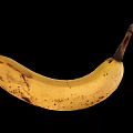 Ripe Banana With Brown Spots On Black Background Curved Shape