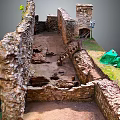 Ancient Ruins Archaeological Site With Stone Walls Earthen Ground Green Tarp And Grass