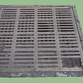 Road Facilities Metal Drainage Grate With Grid Pattern On Urban Street Surface