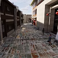 Traditional Commercial Street With Wooden Structure Circular Carved Window And Stone Slab Ground