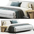 Double Bed With White Bed Sheet Gray And Blue Pillows And Wooden Round Side Table