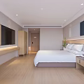 Modern Hotel Guest Room With Large Bed Wall Mounted TV And Wooden Flooring
