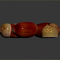 Red And Brown Acorns As Natural Food With Textured Surface On Black Background And Reflections