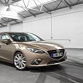 Golden Tan Sedan Car With Modern Sleek Exterior And Alloy Wheels In Indoor Showroom