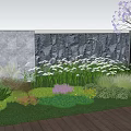 Vibrant Garden With Colorful Flowers Green Lawn Stone Wall Pink Blossom Tree And Wooden Deck