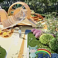 Snail Shaped Children's Playground With Climbing Net Slide Wooden Seats And Green Plants