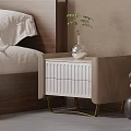 White and Beige Bedside Table with Drawers Gold Legs Glass Vase Green Plant in Bedroom
