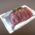 Fresh Raw Tuna Slices Arranged On White Tray With Green Garnish