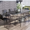 Outdoor Table Set with Black Chairs White Vase and White Flowers on Wooden Deck