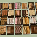 Assorted Decorated Cookies Displayed In Multiple Trays With Various Shapes And Designs