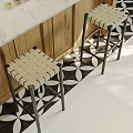 Elegant Modern Kitchen Interior With Woven Bar Stools Marble Countertop And Patterned Floor Tiles