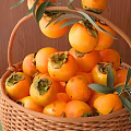 Fresh Ripe Persimmons in Wicker Basket with Green Leaves on Wooden Background and Green Cloth