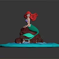 Little Mermaid Figurine Sitting On Rock With Red Hair Green Tail And Blue Water Waves