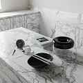 Elegant Decorative Ornament Set with Black Bowl Silver Utensils Transparent Lidded Container on Marble Countertop