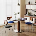 Modern Round Dining Table Set With Colorful Cushioned Chairs In Natural Light Kitchen Area