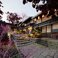 Traditional Commercial Street Featuring Stone Steps Lanterns Red Maple Trees And Illuminated Evening Ambiance