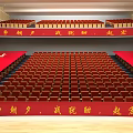 Large Tiered Conference Room With Red Seats And Red Banners On Sides