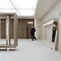 Modern Minimalist Clothing Store Interior With Clothing Racks Sofa And Mirror