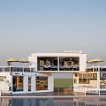 Modern White Container Building Cafe with Terrace Umbrellas and Glass Windows