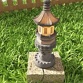 Traditional Pagoda Style Outdoor Light With Stone Base In Green Grass Garden