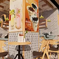 Cozy Cafe Restaurant With Wooden Tables Chairs Yellow Pendant Lights Brick Wall And Drink Posters