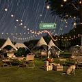 Starry Sky Campsite With White Tents String Lights Green Grass And Relaxing Area