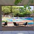 Vibrant Children's Playground with Blue Pink Orange Ground Curved Slides Green Trees and Pink Blossom