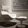 Modern White Lounge Chair With Matching Ottoman And Zebra Print Wall Art On Dark Carpet