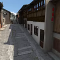 Traditional Chinese Commercial Street With Stone Paved Road Red Lanterns White Walls And Wooden Windows