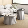 Modern Gray Sofa And Round Pleated Coffee Tables Set With Open Book And Green Plant