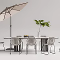 Modern Outdoor Table Setup With Woven Chairs Umbrella Vase And Green Plant