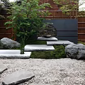 Japanese Garden Landscape With Wooden Fence Green Plants Stone Stepping Path Moss And Large Rocks
