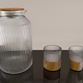 Glass Ribbed Pitcher With Wooden Lid And Yellow Liquid Cups On Black Table