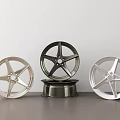 Three Stylish Wheel Rims with Silver Black Chrome Finishes Modern Spoke Design on Dark Countertop