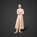 Woman in pink top and beige long skirt with crossed arms standing against gray background